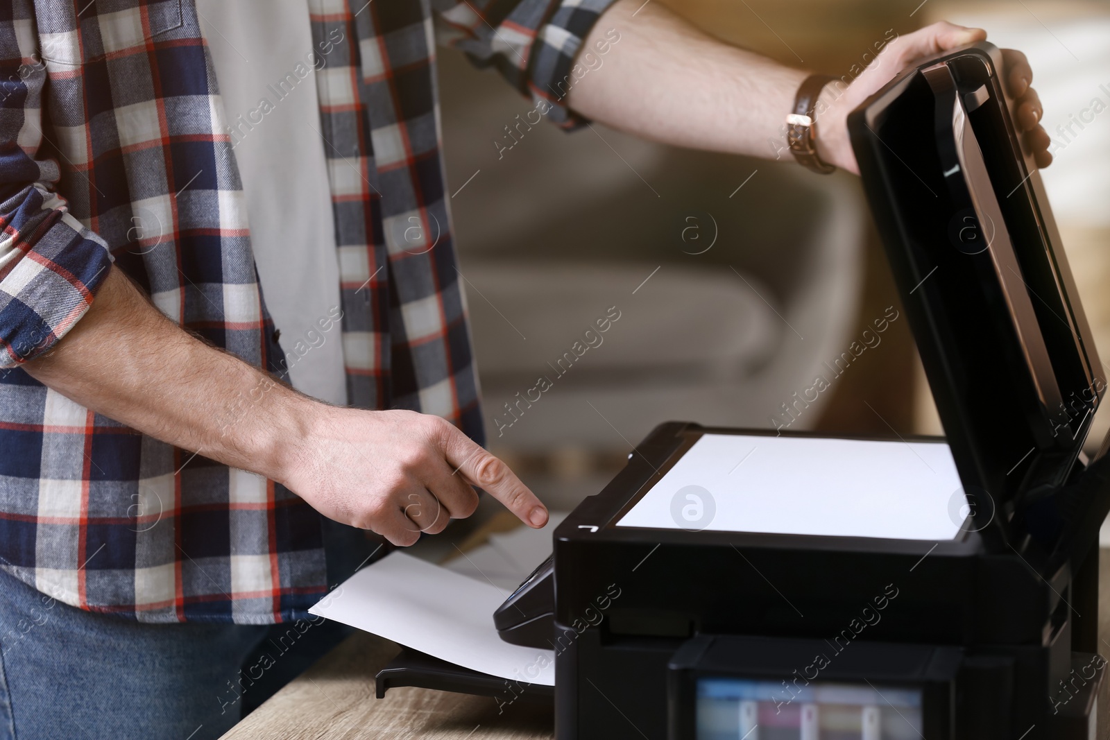 Photo of Man using modern multifunction printer in office, closeup