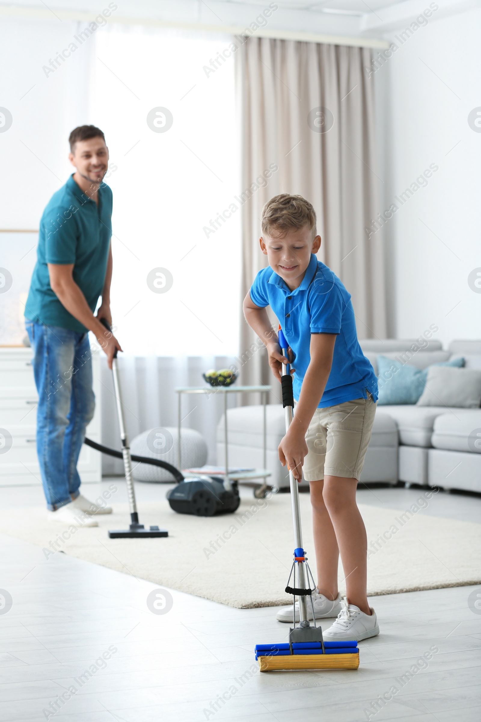 Photo of Dad and son cleaning living room together