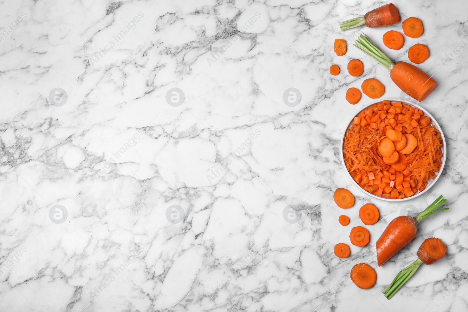 Photo of Flat lay composition with cut carrot on marble background. Space for text