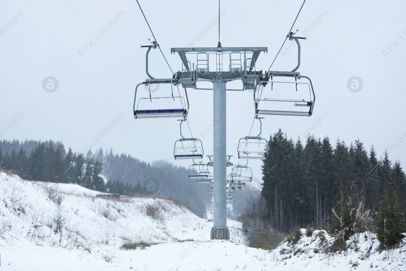 Photo of Chairlift with people at ski resort. Winter vacation