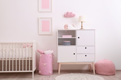 Photo of Nursery interior with comfortable bed and cabinet