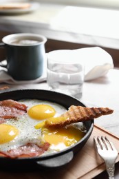 Photo of Tasty fried eggs with bacon and toast on table, closeup