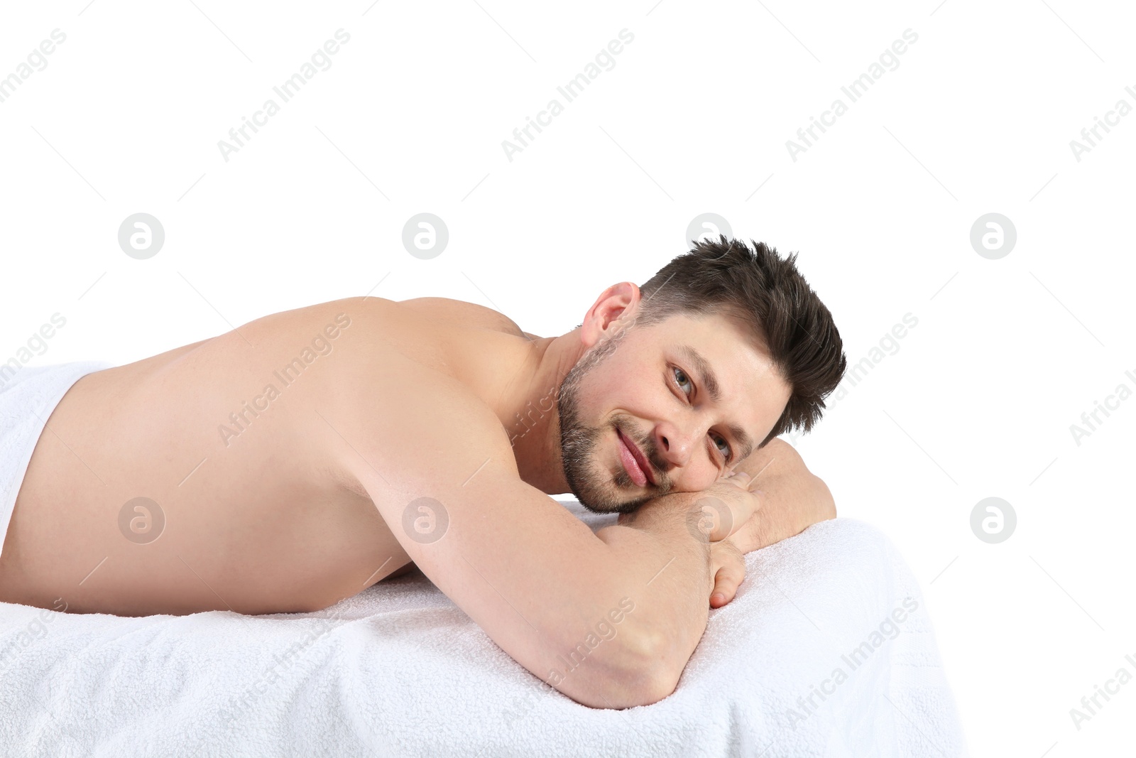 Photo of Handsome man relaxing on massage table against white background. Spa service