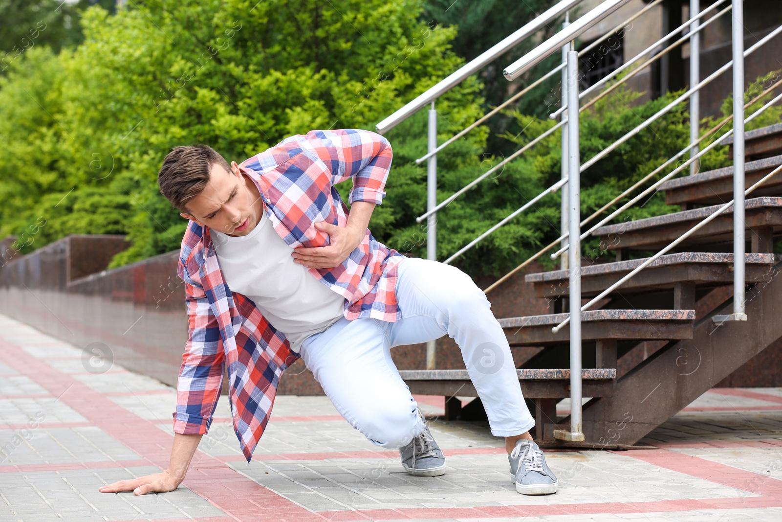 Photo of Young man having chest pain outdoors. Heart attack