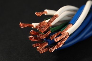 Photo of Electrical wires on black background, closeup view