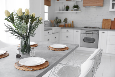 Photo of Elegant table setting in stylish kitchen. Interior design