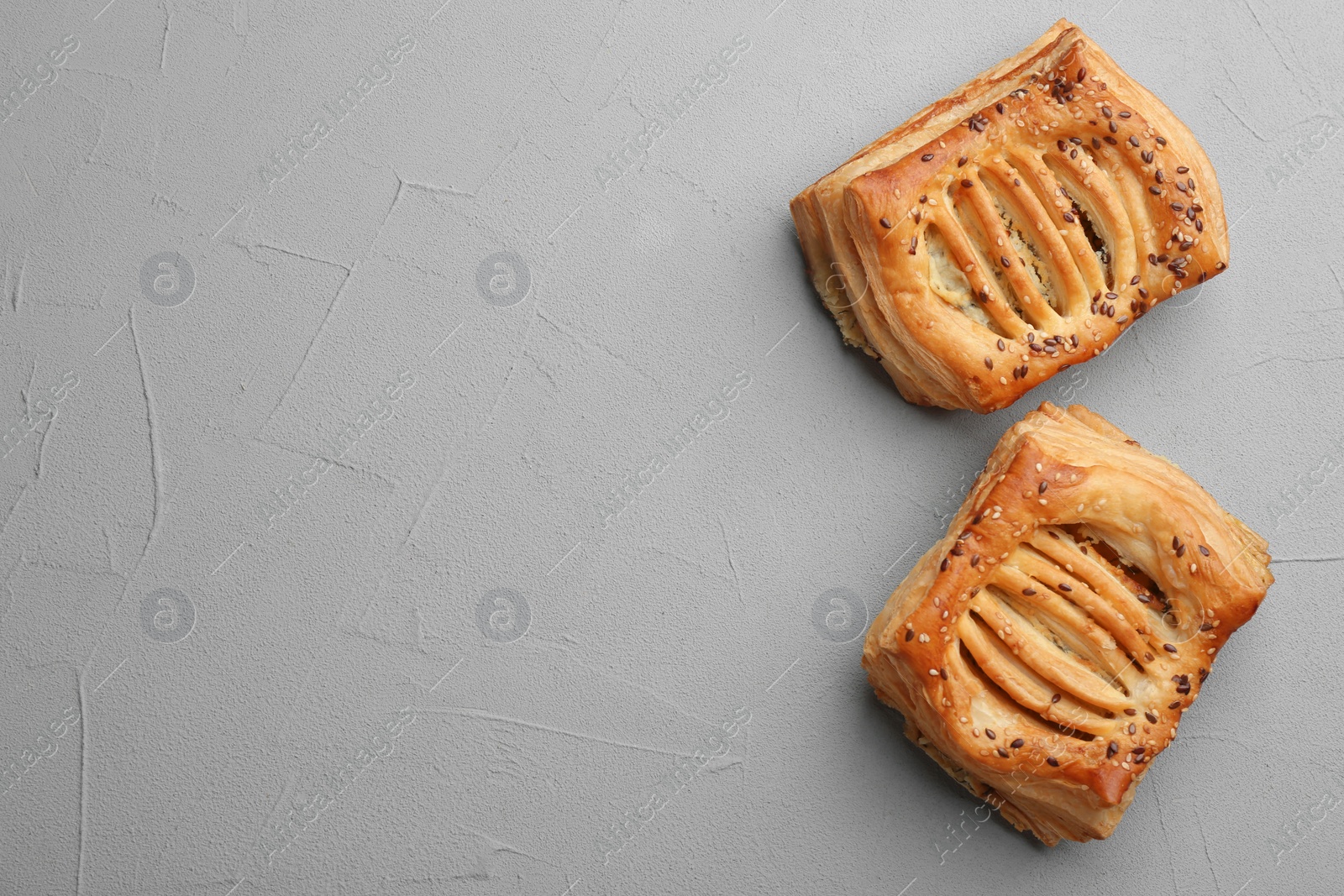 Photo of Fresh delicious puff pastry on grey table, top view. Space for text