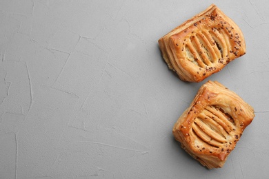 Fresh delicious puff pastry on grey table, top view. Space for text