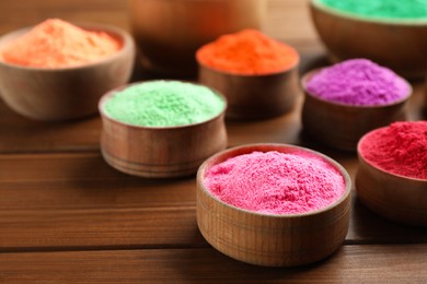 Colorful powder dyes on wooden background, closeup. Holi festival