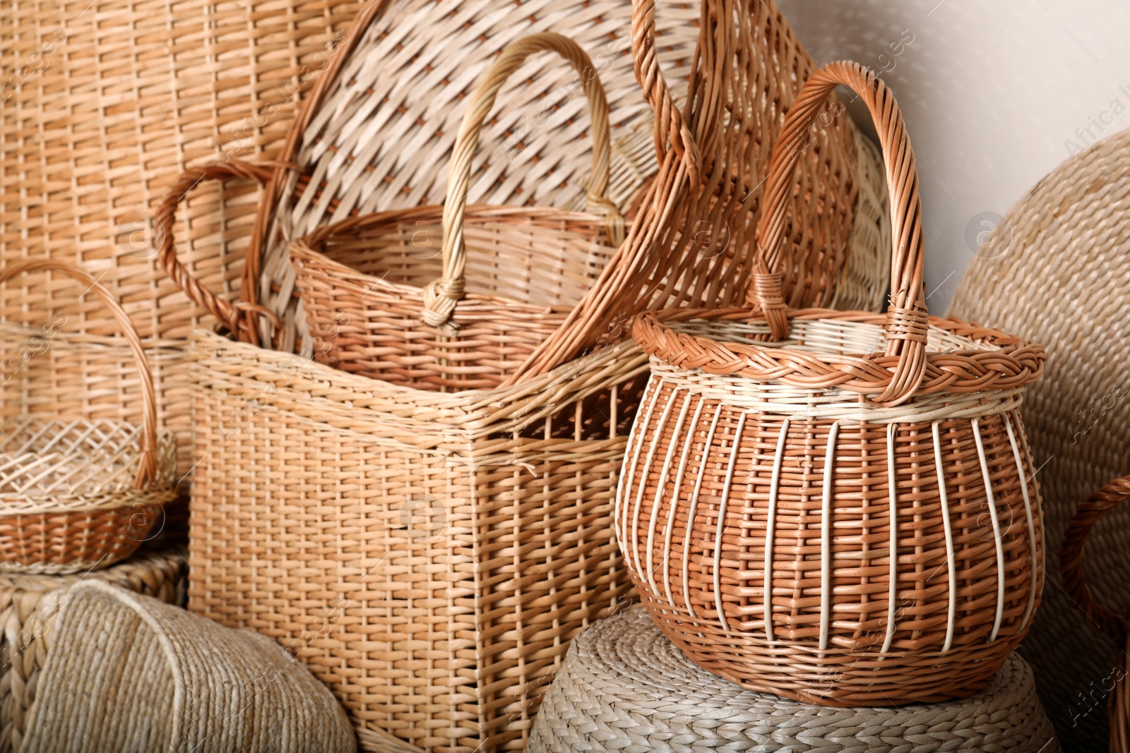 Photo of Many different wicker baskets made of natural material as background, closeup