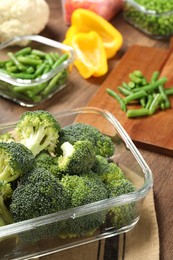 Photo of Containers with broccoli and fresh products on table. Food storage