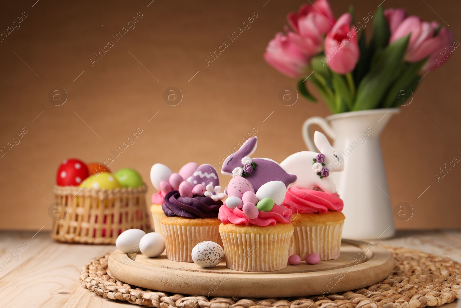 Photo of Tasty cupcakes with Easter decor on wooden table