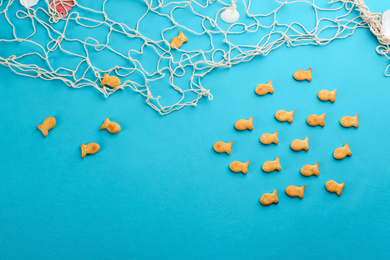 Photo of Underwater life represented with goldfish crackers on blue background, flat lay
