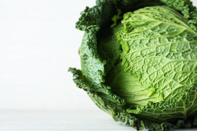 Photo of Fresh ripe savoy cabbage on white table, closeup. Space for text
