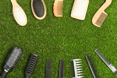 Photo of Flat lay composition with plastic and wooden hairbrushes on green grass, space for text. Recycling concept
