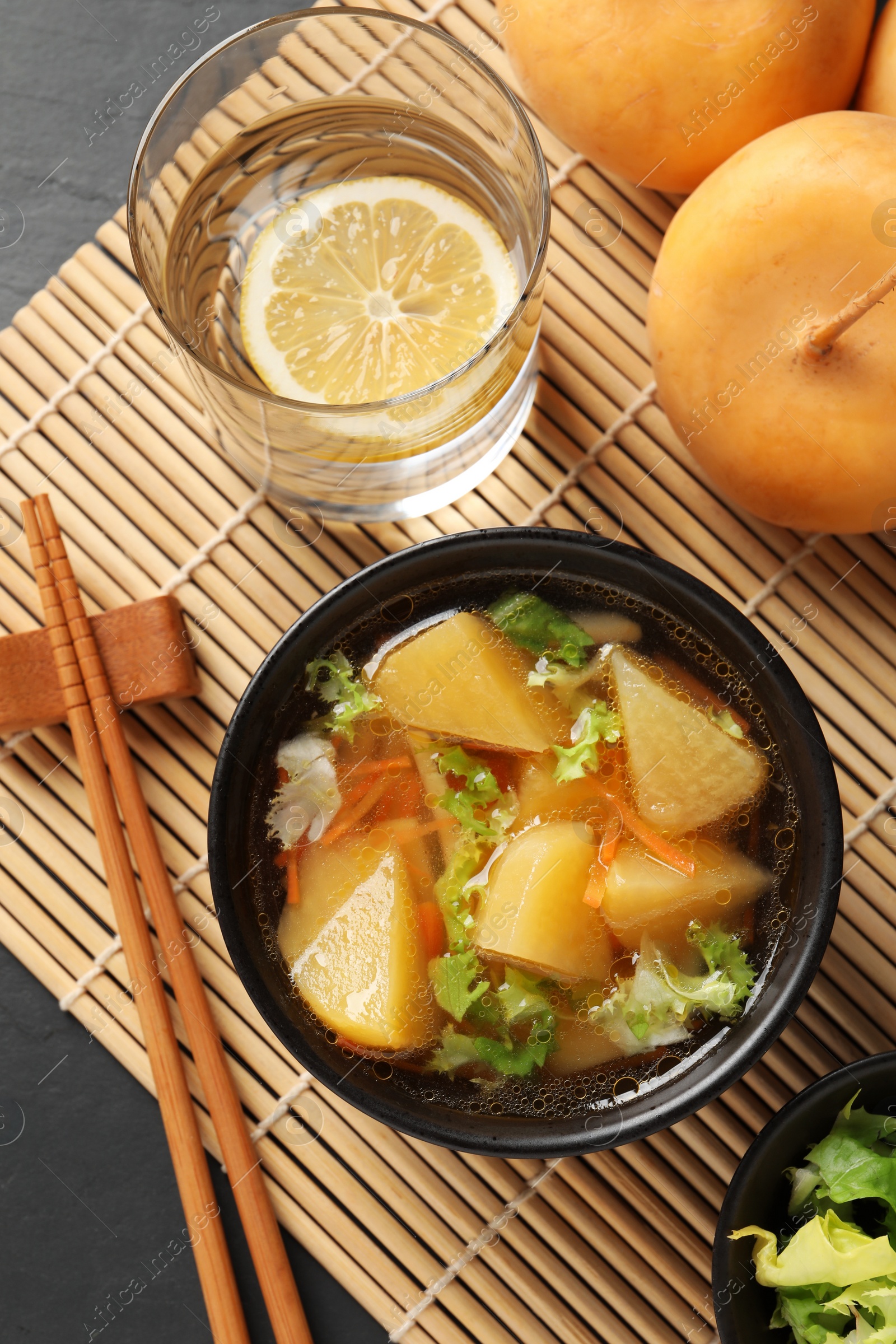 Photo of Bowl of tasty turnip soup served on table, flat lay