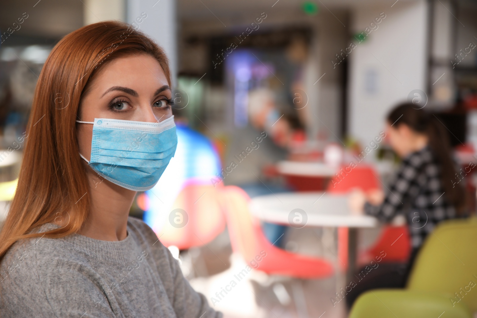 Photo of Woman with medical mask in cafe. Virus protection