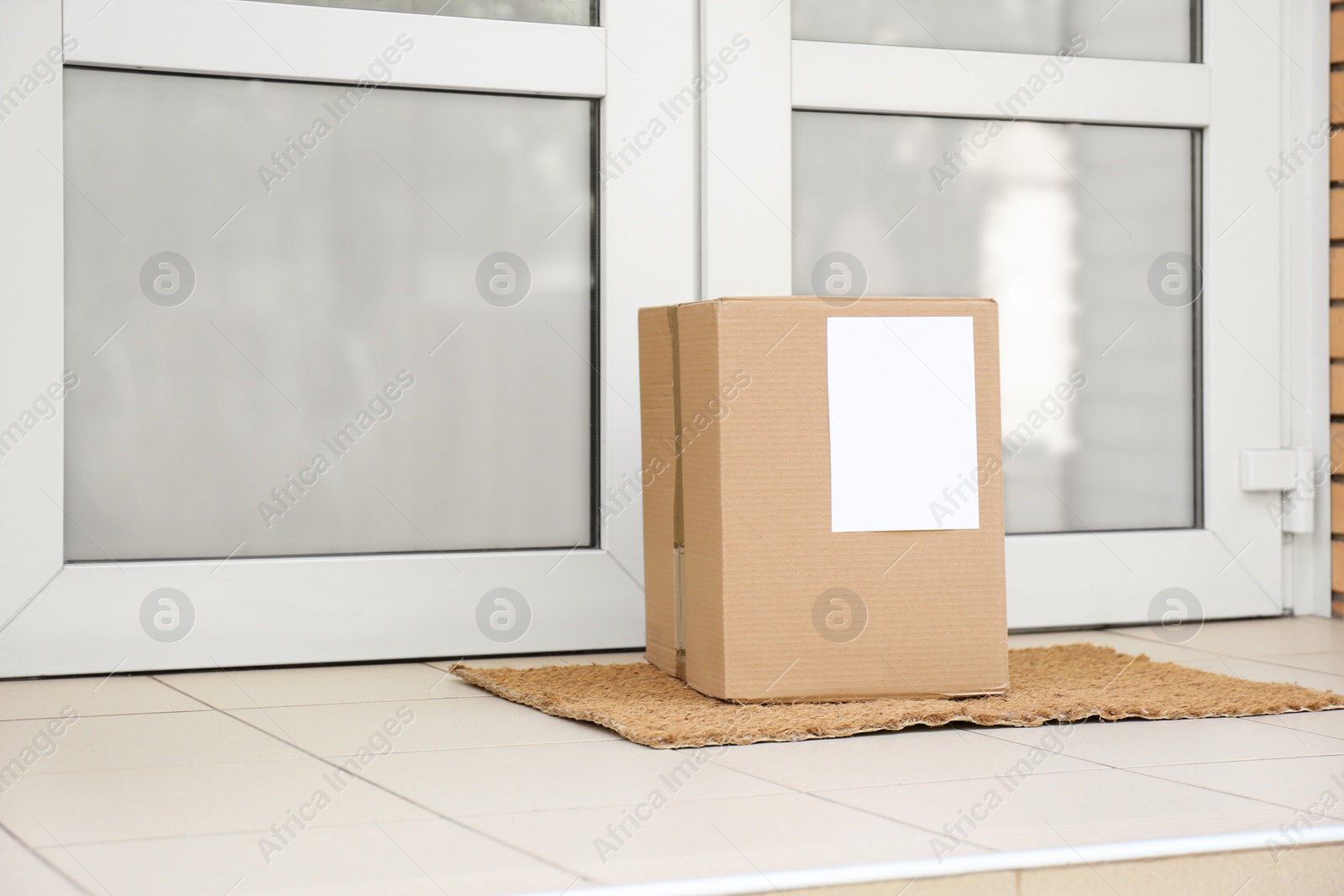 Photo of Delivered parcel on door mat near entrance