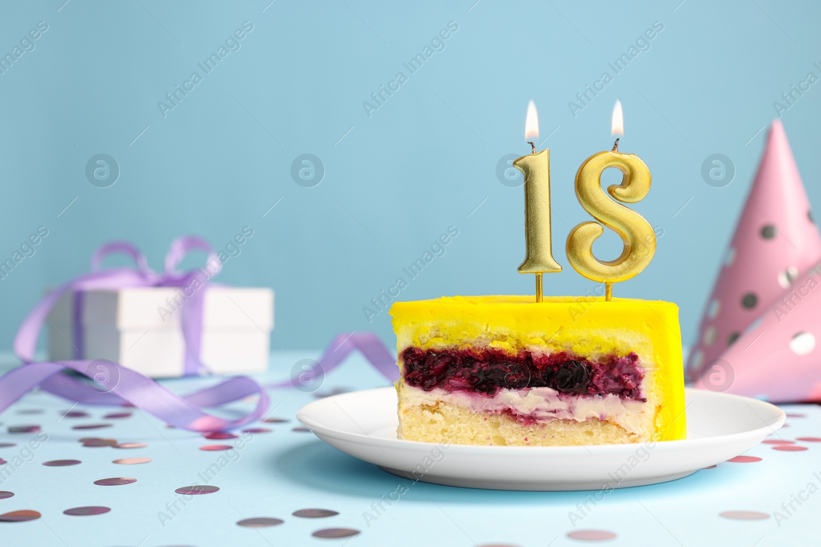 Photo of Coming of age party - 18th birthday. Delicious cake with number shaped candles on light blue background, space for text