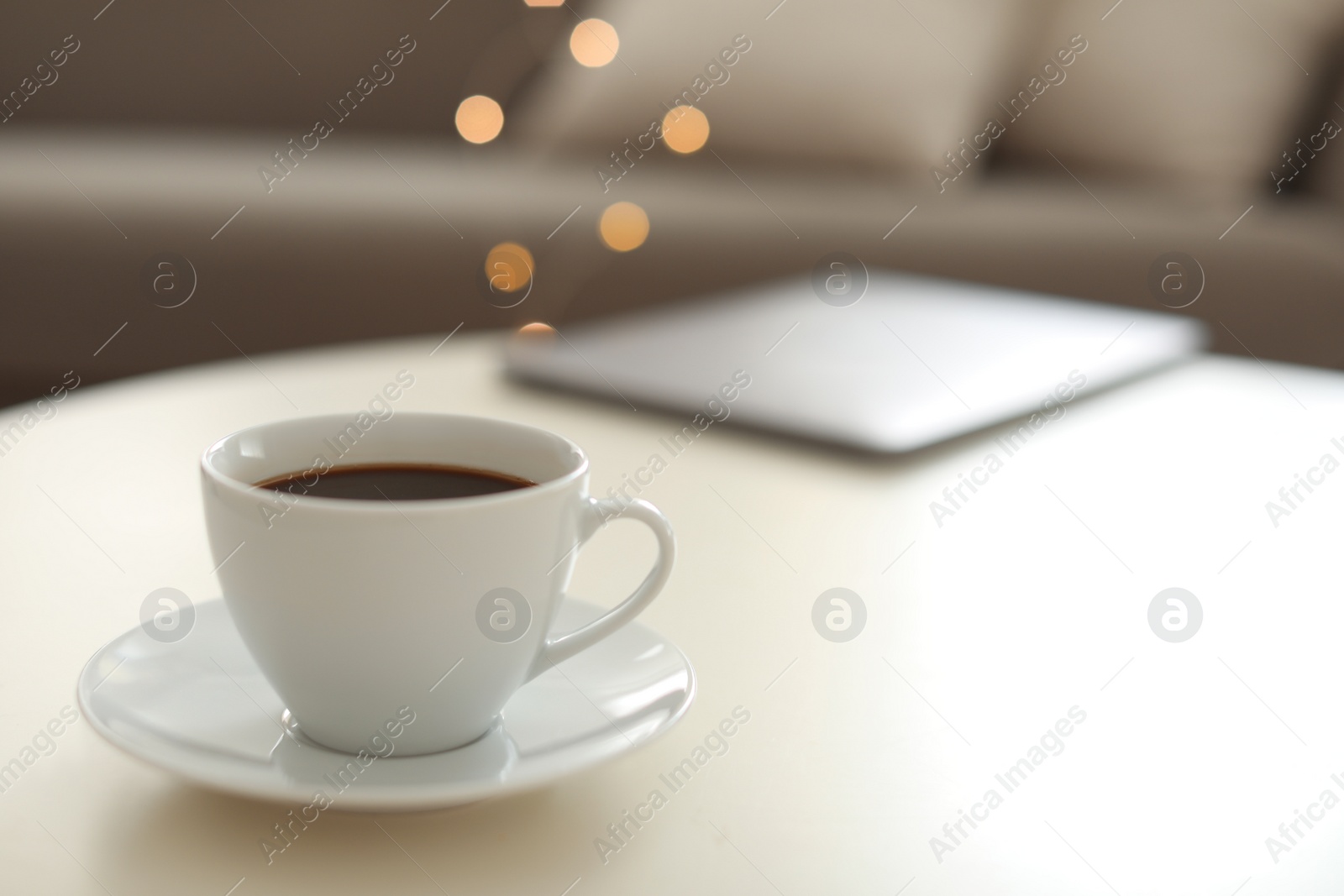 Photo of Cup of coffee on table indoors, space for text. Bokeh effect