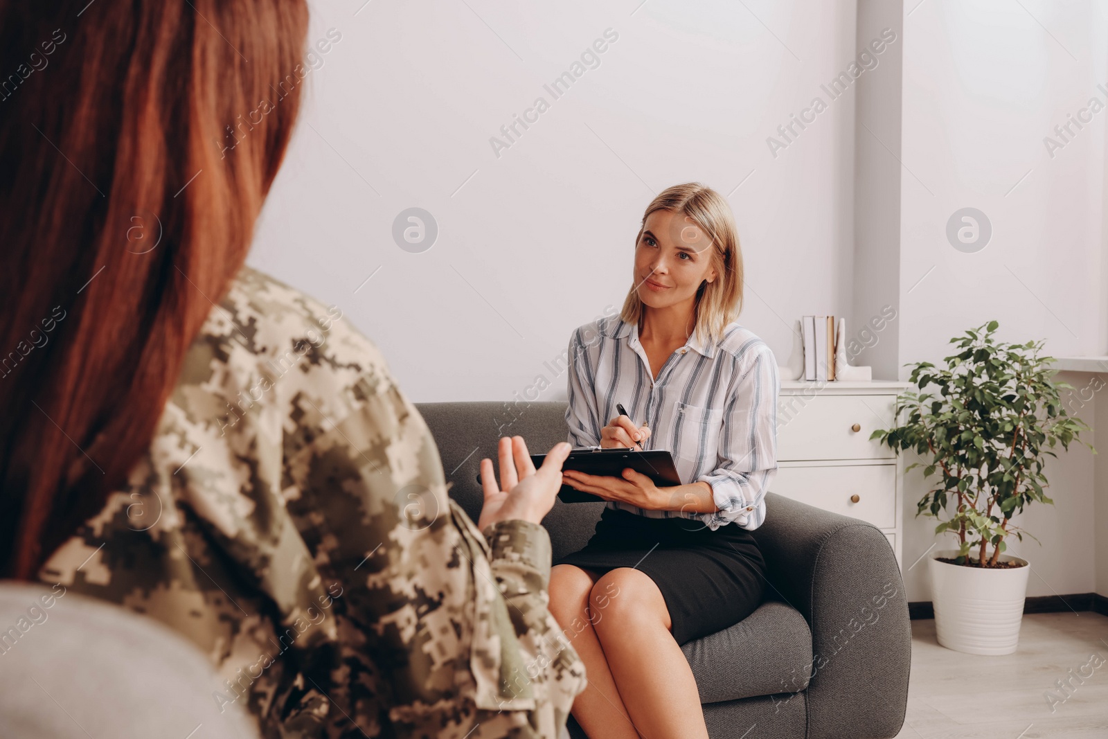 Photo of Psychologist working with female military officer in office