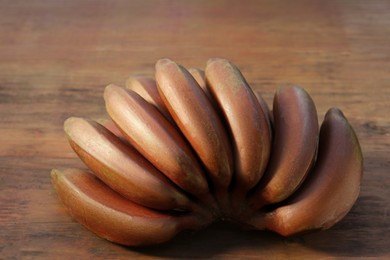 Tasty purple bananas on wooden table, closeup