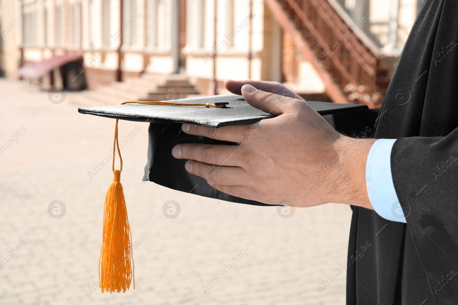 Photo of Student with graduation hat outdoors on sunny day, closeup