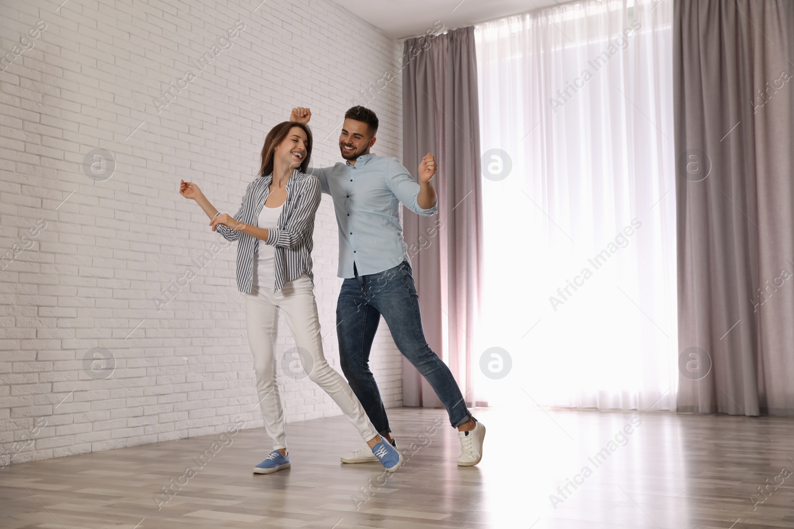 Photo of Lovely young couple dancing together at home