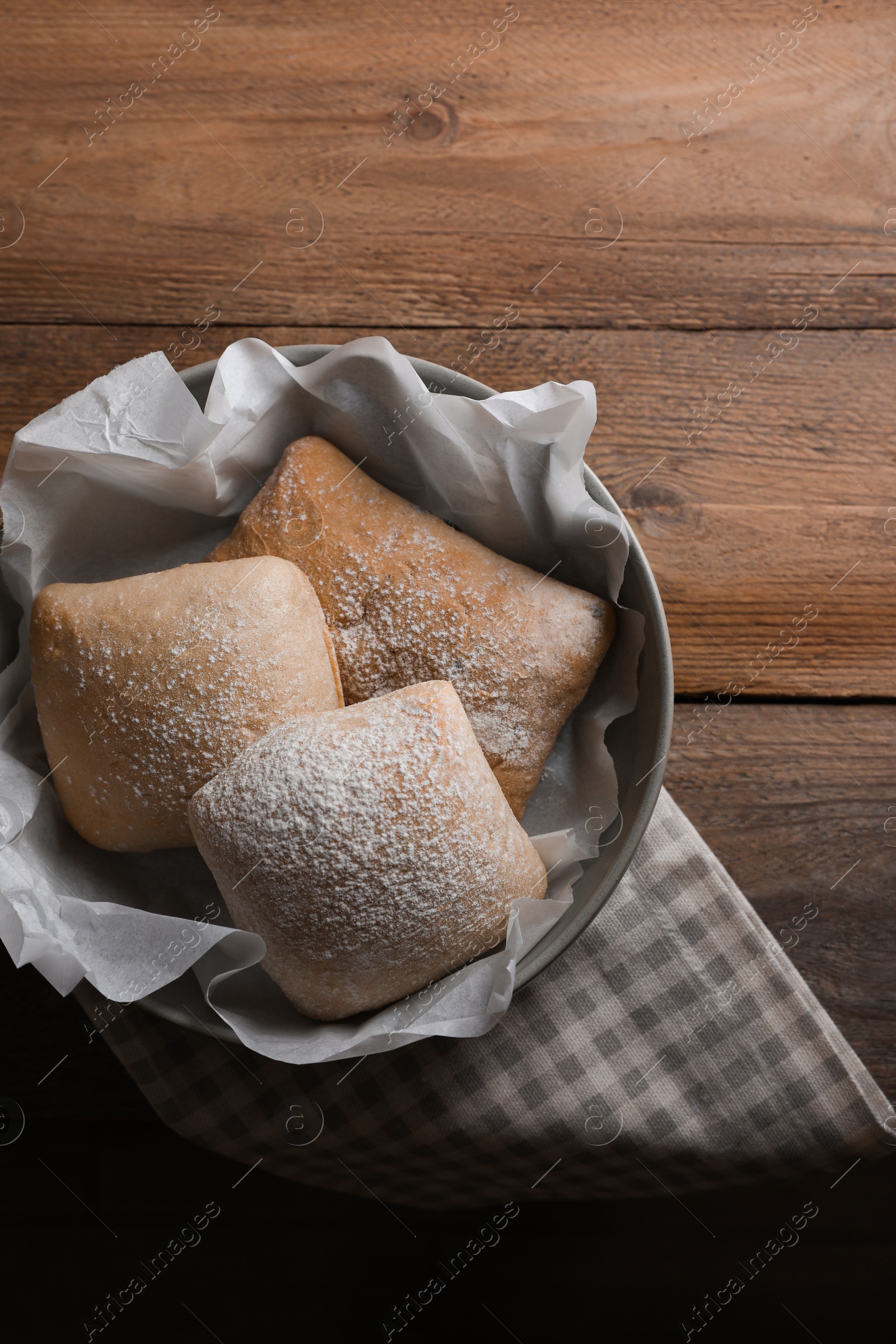 Photo of Fresh crispy ciabattas on wooden table, flat lay. Space for text