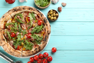 Photo of Tasty pizza with meat and arugula on light blue wooden table, flat lay. Space for text