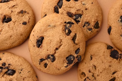 Photo of Delicious chocolate chip cookies on beige background, flat lay