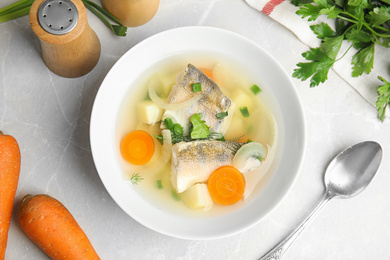 Delicious fish soup served on light table, flat lay