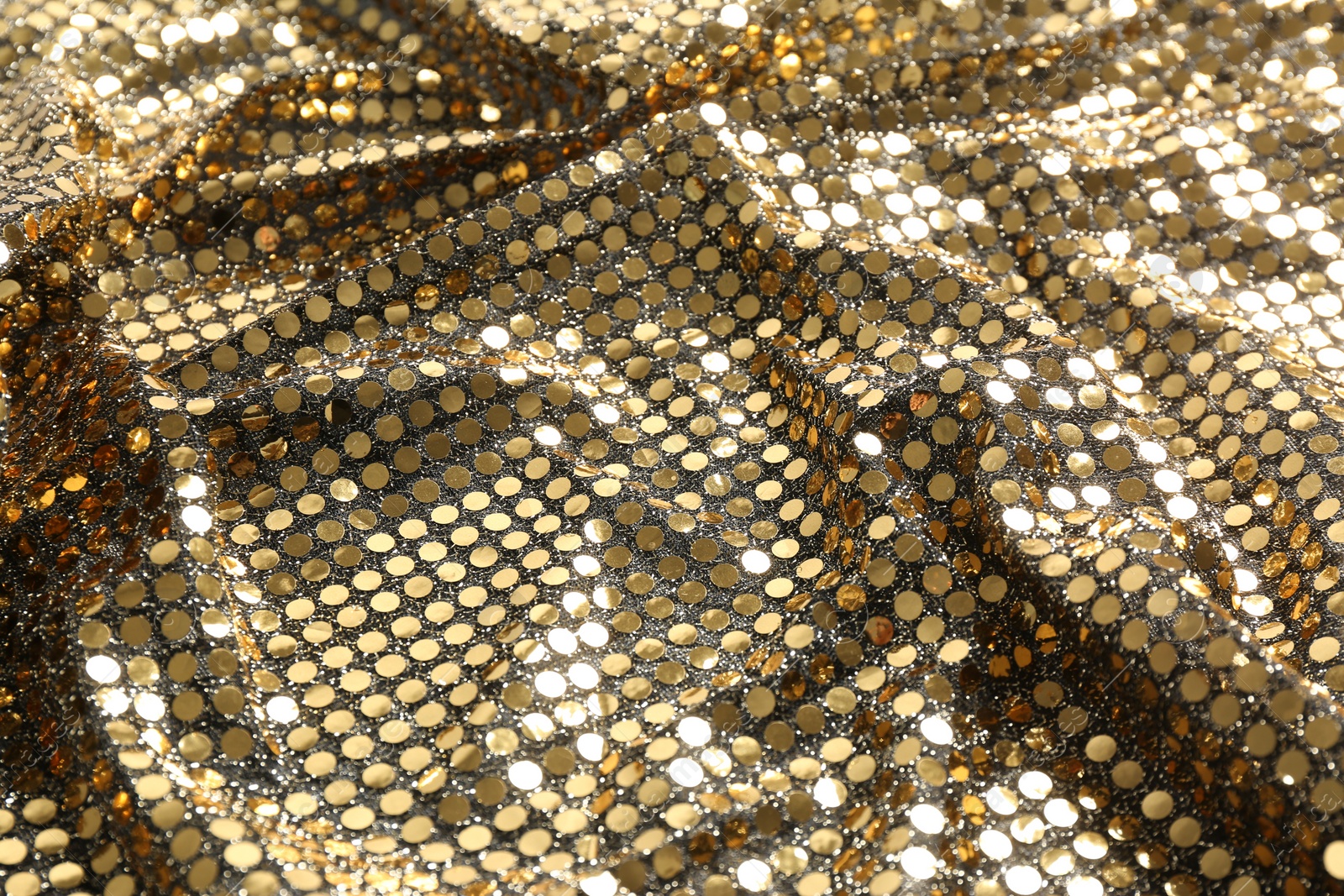 Photo of Closeup view of golden shiny sequin fabric as background