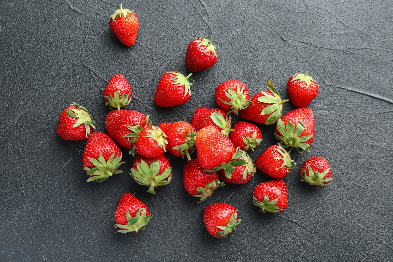 Photo of Ripe red strawberries on black background, top view