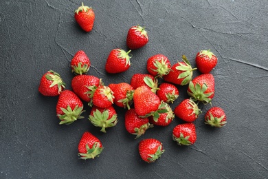 Ripe red strawberries on black background, top view