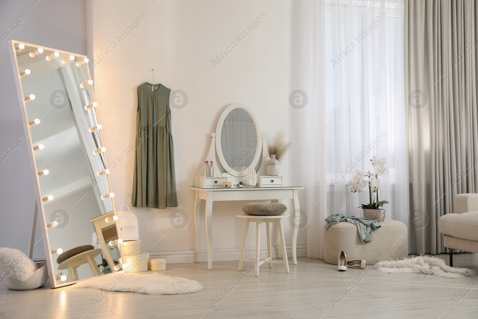 Photo of Large mirror with light bulbs and dressing table in stylish room. Interior design