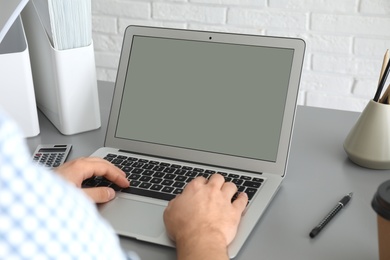 Photo of Man working with laptop at table, closeup. Space for design