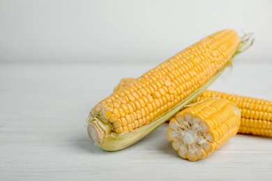 Photo of Tasty sweet corn cobs on wooden table