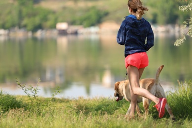 Young woman and her dog spending time together outdoors. Pet care