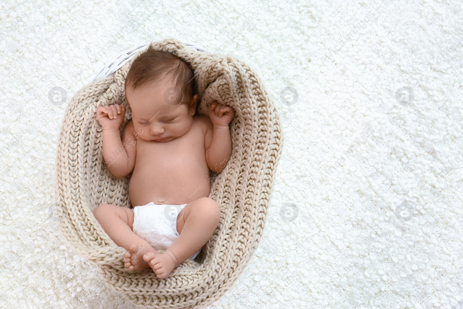 Photo of Cute little baby sleeping in cradle on light background, top view. Space for text