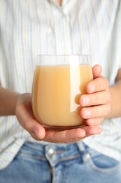 Woman holding tasty pear juice in glass, closeup