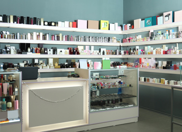 Image of Counter and shelves with perfume bottles in shop