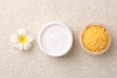 Photo of Body care. Moisturizing cream, sea salt and flower on light textured table, flat lay