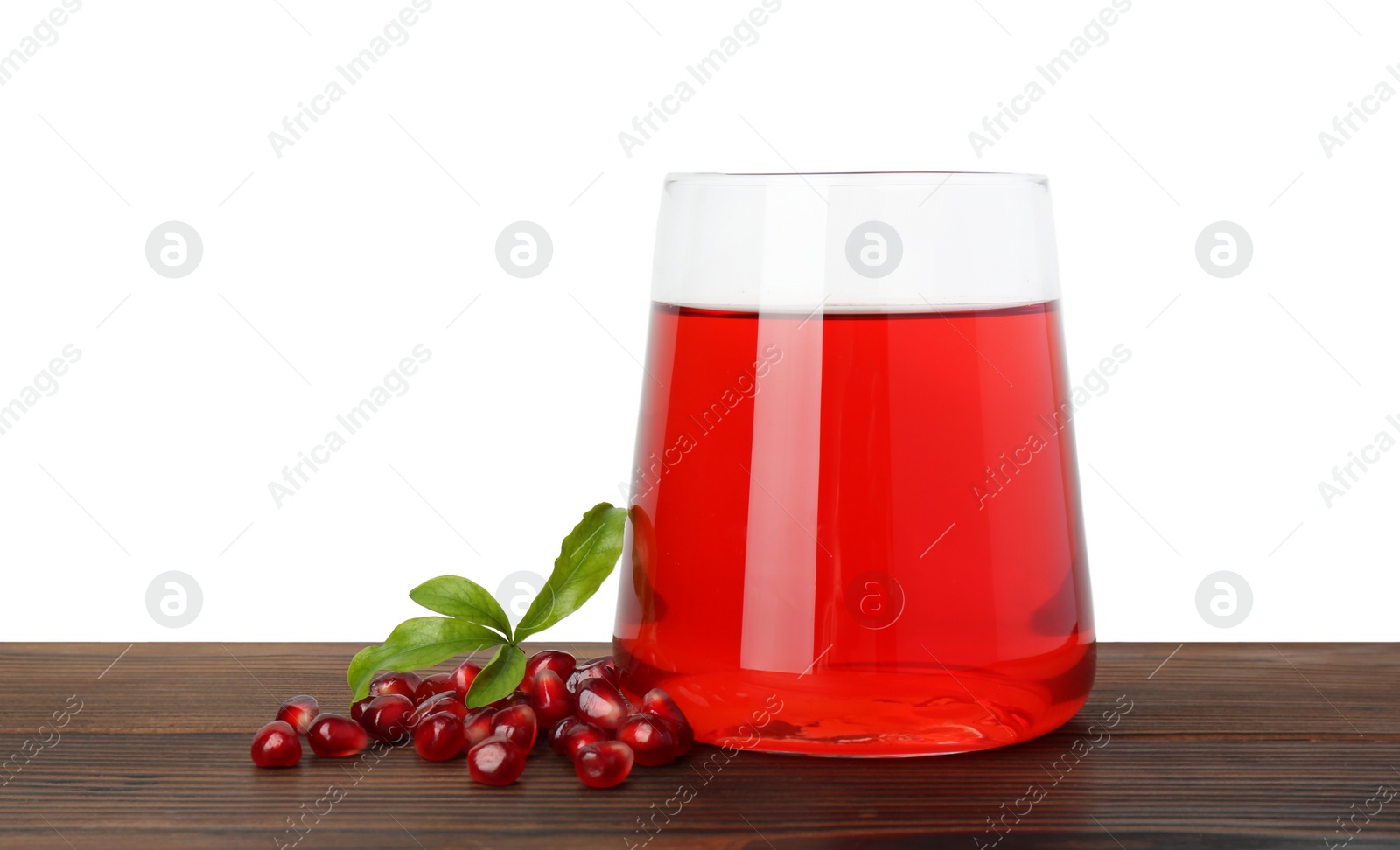 Photo of Refreshing pomegranate juice in glass, leaves and seeds on wooden table against white background