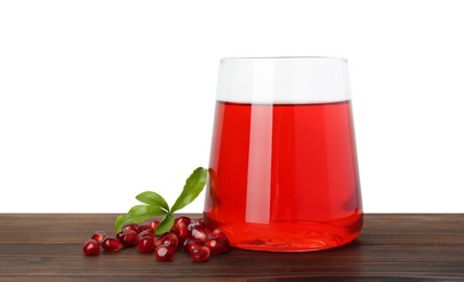 Photo of Refreshing pomegranate juice in glass, leaves and seeds on wooden table against white background