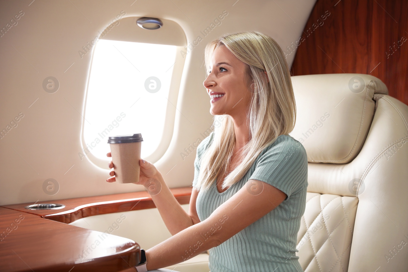 Image of Beautiful woman with paper cup on plane. Air travel