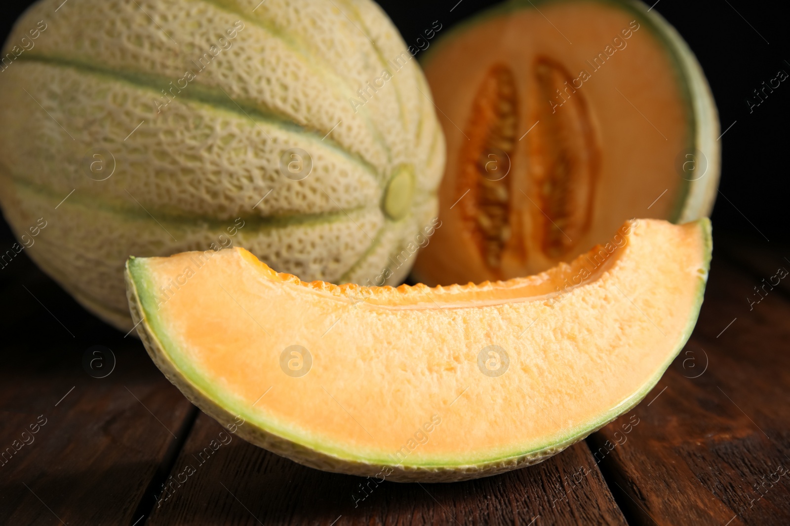 Photo of Slice of tasty fresh melon on wooden table, closeup