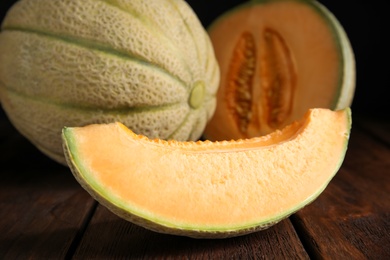 Photo of Slice of tasty fresh melon on wooden table, closeup