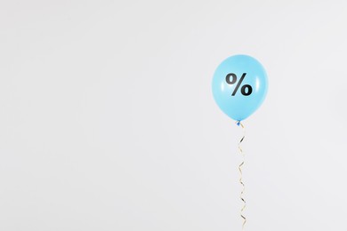 Image of Discount offer. Light blue balloon with percent sign on white background, space for text