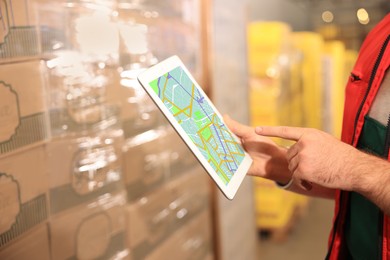 Image of Man with tablet working at warehouse, closeup. Logistics center